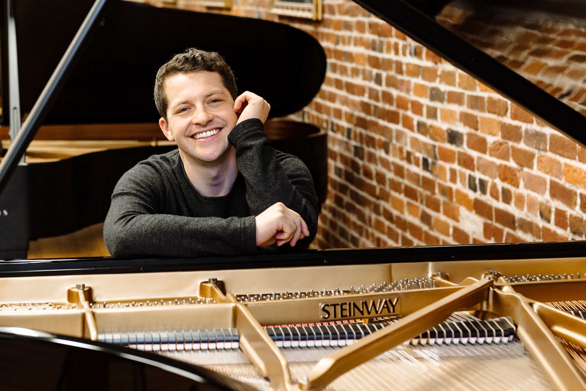 Portrait of Henry Kramer in front of a piano